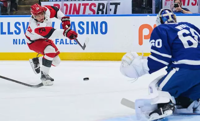 Carolina Hurricanes' Seth Jarvis (24) shoots against Toronto Maple Leafs goaltender Joseph Woll (60) during first-period NHL hockey game action in Toronto, Friday, March 20, 2026. (Sammy Kogan/The Canadian Press via AP)