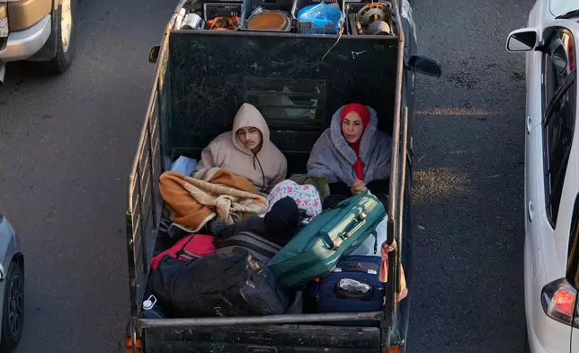 Displaced people fleeing Israeli strikes in southern Lebanon sit on a pickup at a highway links to Beirut, in the southern port city of Sidon, Monday, March 2, 2026. (AP Photo/Mohammed Zaatari)
