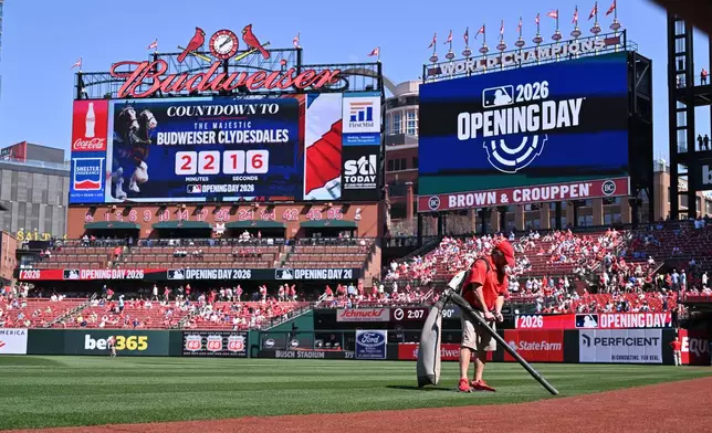 A member of the grounds crew cleans the field prior to an opening-day baseball game between the St. Louis Cardinals and the Tampa Bay Rays, Thursday, March 26, 2026, in St. Louis. (AP Photo/Jeff Le)