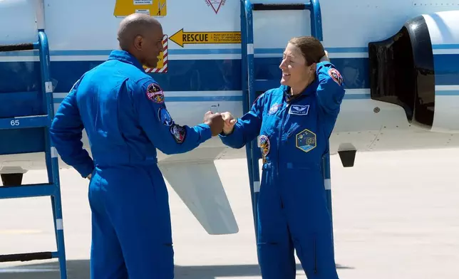 Artemis 2 crew members, pilot Victor Glover, left, and Mission Specialist Christina Koch, fist bump after the crew's arrival at the Kennedy Space Center Friday, March 27, 2026, in Cape Canaveral, Fla. (AP Photo/Chris O'Meara)