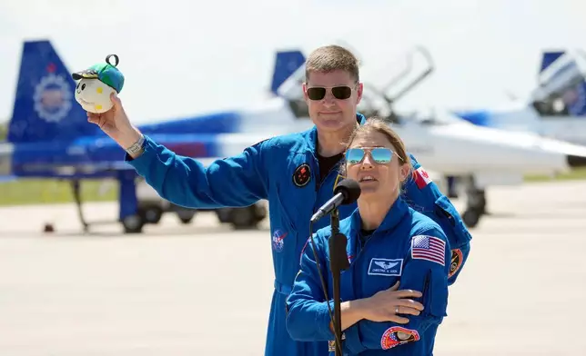 Artemis 2 crew members, Mission Specialist Christina Koch, front and Mission Specialist Jeremy Hansen, of Canada, speaks to the media after the crew's arrival at the Kennedy Space Center Friday, March 27, 2026, in Cape Canaveral, Fla. (AP Photo/Chris O'Meara)
