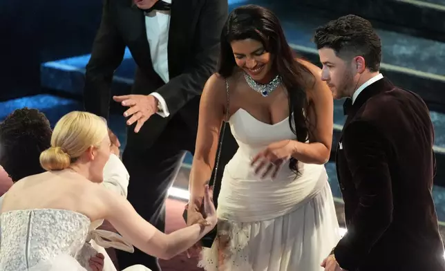 Elle Fanning, from left, Priyanka Chopra Jonas, and Nick Jonas in the audience during the Oscars on Sunday, March 15, 2026, at the Dolby Theatre in Los Angeles. (AP Photo/Chris Pizzello)