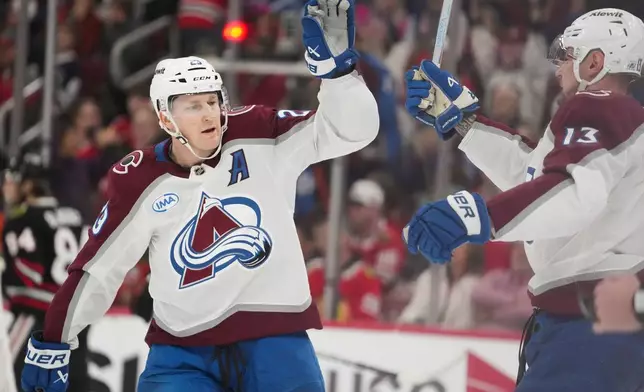 Colorado Avalanche center Nathan MacKinnon, left, and right wing Valeri Nichushkin (13) celebrate after a goal by center Martin Necas during the first period of an NHL hockey game against the Chicago Blackhawks, Friday, March 20, 2026, in Chicago. (AP Photo/Erin Hooley)