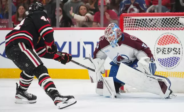 Chicago Blackhawks defenseman Wyatt Kaiser, left, scores against Colorado Avalanche goaltender MacKenzie Blackwood, right, during the second period of an NHL hockey game Friday, March 20, 2026, in Chicago. (AP Photo/Erin Hooley)