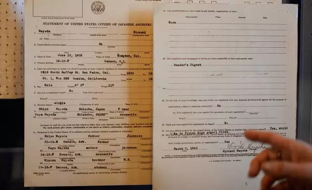 Rosalyn Tonai, Executive Director at the National Japanese American Historical Society, gestures toward a Hiroshi Mayeda's Statement of United States Citizen of Japanese Ancestry displayed in the "I am an American: The Nisei Soldier Experience" exhibit at the Military Intelligence Service Historic Learning Center in San Francisco, Wednesday, Feb. 25, 2026. (AP Photo/Jeff Chiu)