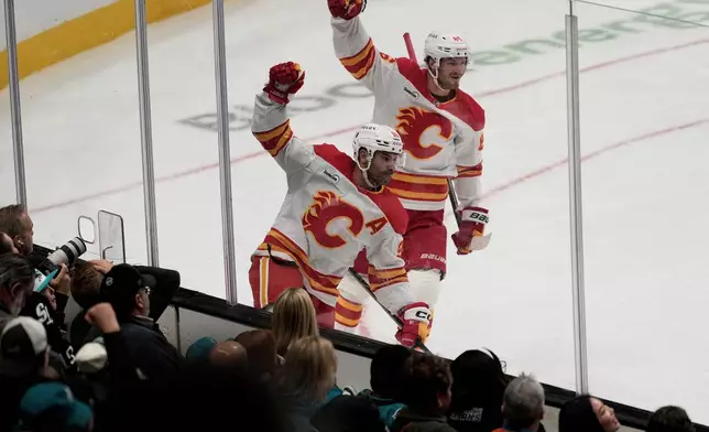 Calgary Flames center Nazem Kadri, middle, celebrates after scoring a goal next to left wing Joel Farabee (86) during the third period of an NHL hockey game against the San Jose Sharks in San Jose, Calif., Thursday, Feb. 26, 2026. (AP Photo/Jeff Chiu)