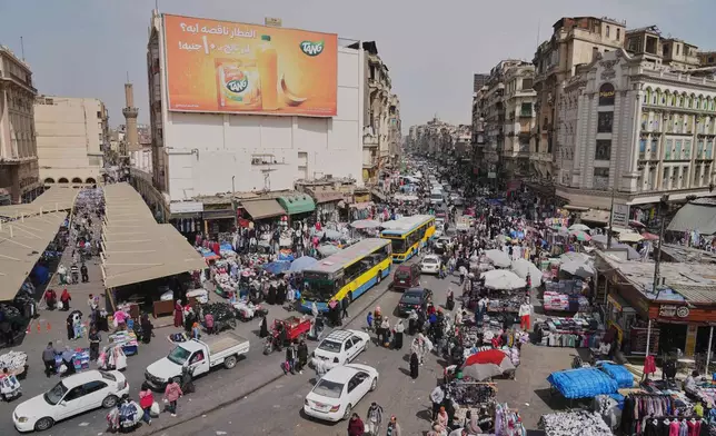 A view of people and vehicles at a popular market in Cairo, Egypt, Tuesday, March 12, 2026. (AP Photo/Amr Nabil)