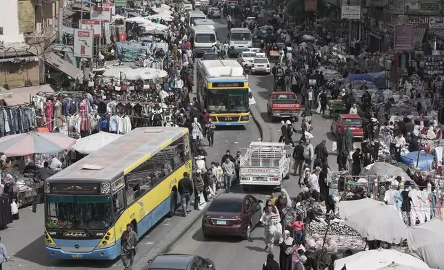 People and vehicles crowd at a popular market in Cairo, Egypt, Tuesday, March 12, 2026. (AP Photo/Amr Nabil)