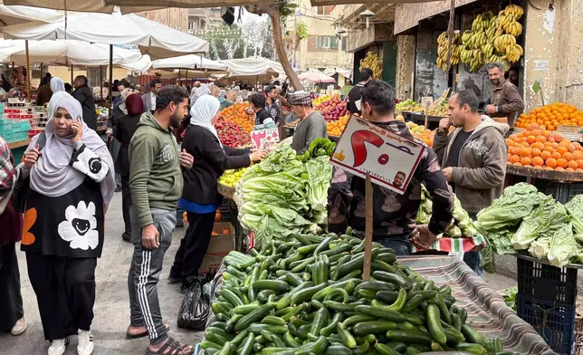 People buy vegetables at a popular market in Cairo, Egypt, Tuesday, March 12, 2026. (AP Photo/Amr Nabil)