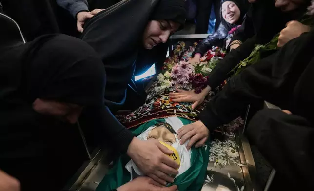 The mother of Jawad Younes,11, who was killed on Friday in an Israeli airstrike, mourns over his body during a funeral procession in Saksakiyeh village, south Lebanon, Saturday, March 28, 2026. (AP Photo/Hussein Malla)