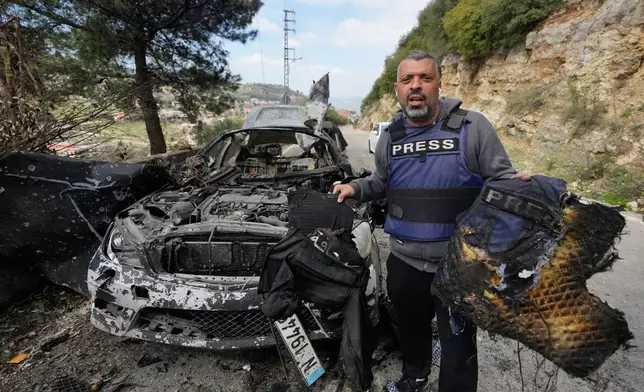 A journalist carries burned safety gear, following an Israeli airstrike on a car that killed Hezbollah's al-Manar TV correspondent Ali Shoeib, Beirut's based Al-Mayadeen TV reporter Fatima Ftouni and her brother, video journalist Mohammed Ftouni, in the town of Jezzine, south Lebanon, Saturday, March 28, 2026. (AP Photo/Mohammed Zaatari)