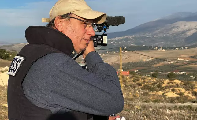 Hezbollah's al-Manar TV correspondent Ali Shoeib, who was killed in an Israeli strike in Jezzine with other journalists on Saturday, March 28, 2026, speaks on his mobile phone in Marjayoun town, Wednesday, Nov. 22, 2024. (AP Photo/Hussein Malla)