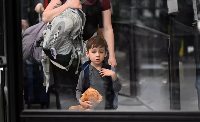 A young passenger waits in line with his mother to be checked in with TSA at O'Hare Airport in Chicago, Thursday, March 26, 2026. (AP Photo/Paul Beaty)