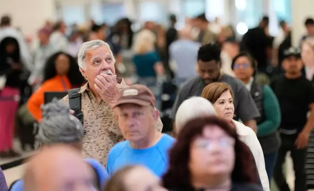 Passengers wait in a security checkpoint line at George Bush Intercontinental Airport, Wednesday, March 25, 2026, in Houston. (AP Photo/David J. Phillip)