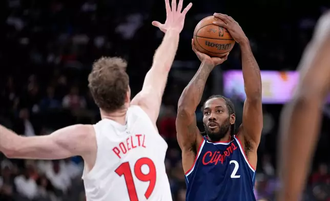 Los Angeles Clippers forward Kawhi Leonard, right, shoots as Toronto Raptors center Jakob Poeltl defends during the first half of an NBA basketball game Wednesday, March 25, 2026, in Inglewood, Calif. (AP Photo/Mark J. Terrill)