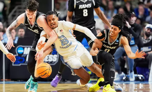 North Carolina forward Jarin Stevenson vies for the ball with VCU forward Lazar Djokovic, left, and guard Brandon Jennings during the second half in the first round of the NCAA college basketball tournament, Thursday, March 19, 2026, in Greenville, S.C. (AP Photo/Chris Carlson)