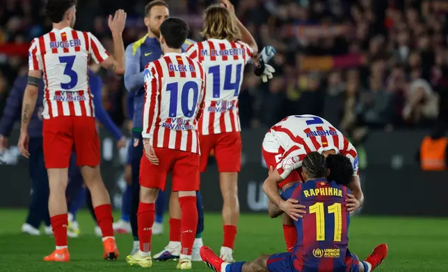 Atletico Madrid's Johnny Cardoso hugs Barcelona's Raphinha after during the Copa del Rey semifinal second leg soccer match between Barcelona and Atletico Madrid in Barcelona, Spain, Tuesday, March 3, 2026. (AP Photo/Joan Monfort)