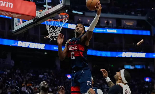Washington Wizards center Alex Sarr (20) rebounds the ball next to Golden State Warriors guard Gary Payton II, right, during the first half of an NBA basketball game, Friday, March 27, 2026, in San Francisco. (AP Photo/Godofredo A. Vásquez)