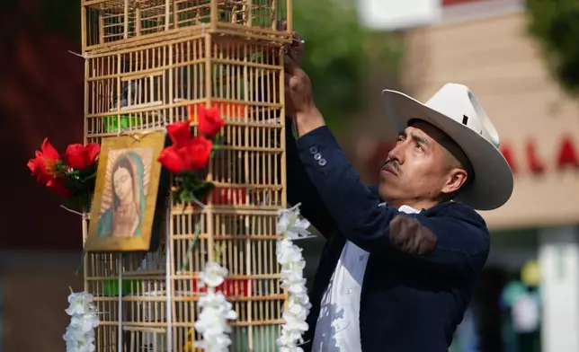 A vendor prepares a cage containing his birds before an annual pilgrimage of bird vendors to the Basilica of Guadalupe in Mexico City, Sunday, March 29, 2026. (AP Photo/Eduardo Verdugo)