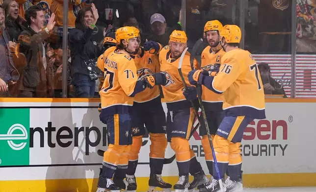 Nashville Predators right wing Luke Evangelista (77) celebrates his goal with teammates during the first period of an NHL hockey game against the San Jose Sharks, Tuesday, March 24, 2026, in Nashville, Tenn. (AP Photo/George Walker IV)