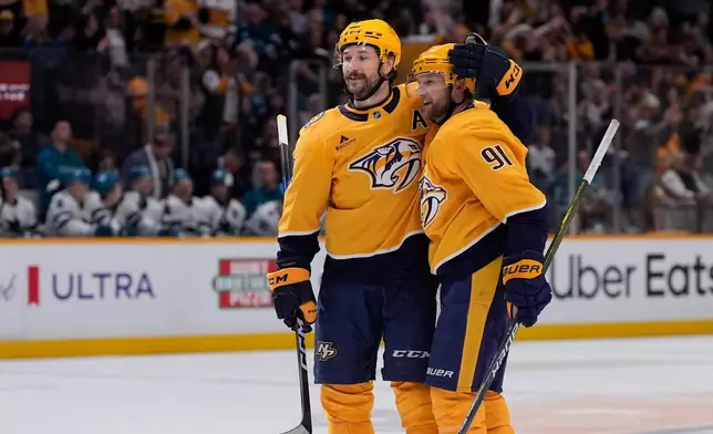 Nashville Predators left wing Filip Forsberg, left, congratulates center Steven Stamkos (91) after his goal during the second period of an NHL hockey game against the San Jose Sharks, Tuesday, March 24, 2026, in Nashville, Tenn. (AP Photo/George Walker IV)