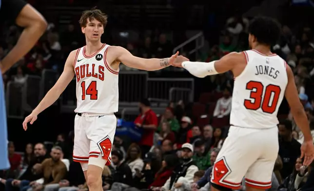 Chicago Bulls' Matas Buzelis (14) celebrates with teammate Tre Jones (30) during the first half of an NBA basketball game against the Memphis Grizzlies in Chicago, Monday, March 16, 2026. (AP Photo/Paul Beaty)