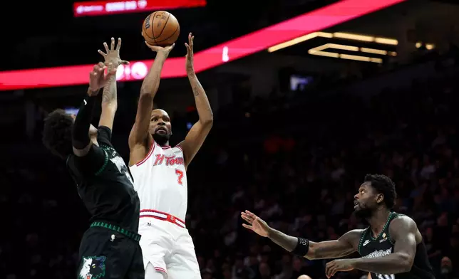 Houston Rockets forward Kevin Durant (7) shoots against Minnesota Timberwolves forward Jaden McDaniels, left, and forward Julius Randle (30) during the first half of an NBA basketball game, Wednesday, March 25, 2026, in Minneapolis. (AP Photo/Ellen Schmidt)