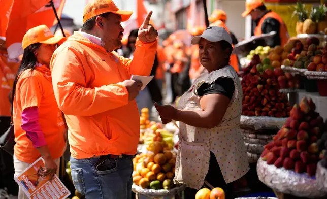 Congressman Carlos Carreño Marín, who goes by Sergio Marin, of the Comunes party, talks with a vendor while campaigning for reelection ahead of legislative elections in Bogota, Colombia, Thursday, Feb. 26, 2026. (AP Photo/Fernando Vergara)