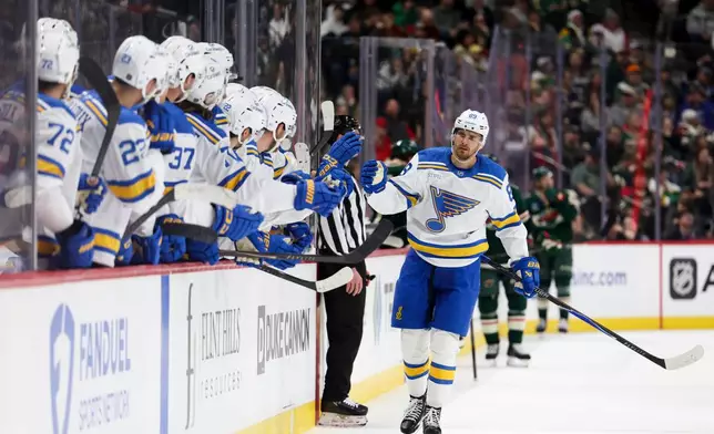 St. Louis Blues left wing Pavel Buchnevich celebrates at the bench after scoring a goal during the third period of an NHL hockey game against the Minnesota Wild, Sunday, March 1, 2026, in St. Paul, Minn. (AP Photo/Ellen Schmidt)