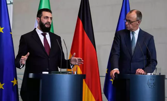 German Chancellor Friedrich Merz, right, and Syrian President Ahmad al-Sharaa attend a press conference in Berlin, Germany, Monday, March 30, 2026. (AP Photo/Markus Schreiber)