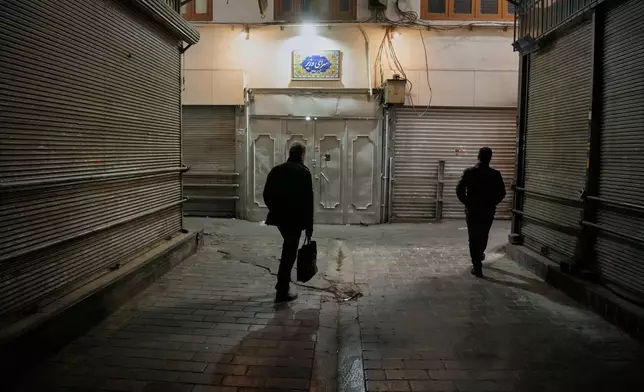 People walk past closed shops at the nearly empty traditional main bazaar in Tehran, Iran, Tuesday, March 10, 2026. (AP Photo/Vahid Salemi)