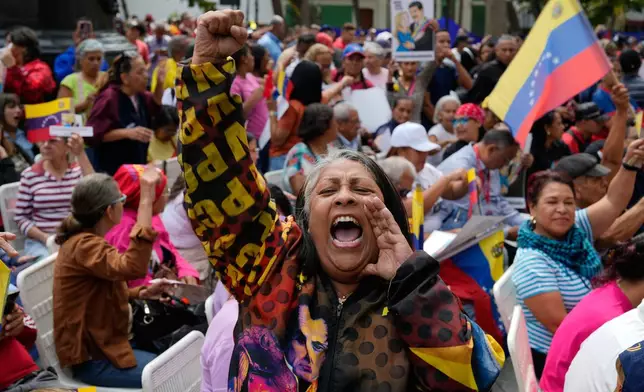 A woman screams during a government-organized event to watch former President Nicolas Maduro and first lady Cilia Flores appear in a New York court on a screen in Caracas, Venezuela, Thursday, March 26, 2026. (AP Photo/Ariana Cubillos)