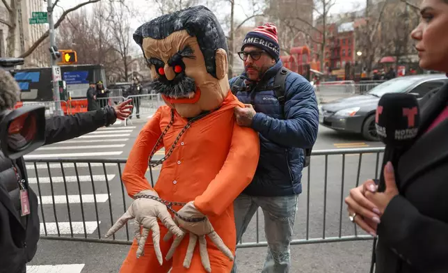 A demonstrator drags an effigy of former Venezuela President Nicolas Maduro outside Manhattan federal court before a pre-trial hearing in Maduro's drug trafficking case, Thursday, March 26, 2026, in New York. (AP Photo/Heather Khalifa)