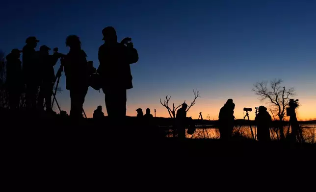 Early-rising birders await sunrise at Middle Creek Wildlife Management Area, Monday, March 9, 2026, in Kleinfeltersville, Pa. (AP Photo/Robert F. Bukaty)