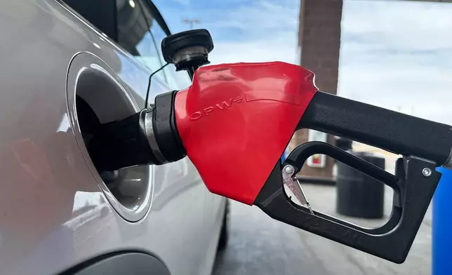 A motorist fills up the tank of a vehicle at a Coscto gasoline station Thursday, March 12, 2026, in east Denver. (AP Photo/David Zalubowski)