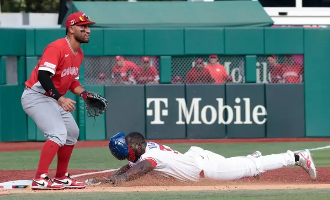 Cuba's Yoel Yanqui slides in safe at third base as Canada's Abraham Toro looks on during the fifth inning of a World Baseball Classic game in San Juan, Puerto Rico, Wednesday, March 11, 2026. (AP Photo/Alejandro Granadillo)