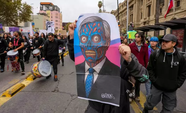 A protester holds an image representing Chile's President Jose Antonio Kast during a march on World Water Day demanding greater environmental protection and animal welfare in Santiago, Chile, Sunday, March 22, 2026. (AP Photo/Esteban Felix)