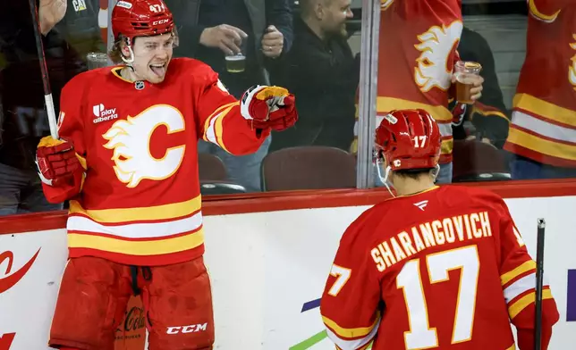 Calgary Flames' Connor Zary, left, celebrates his goal with teammate Yegor Sharangovich during the first period of an NHL hockey game in Calgary on Wednesday, March 18, 2026. (Jeff McIntosh/The Canadian Press via AP)
