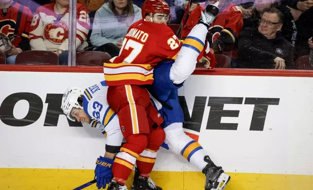 St. Louis Blues' Jake Neighbours, left, is checked by Calgary Flames' Matt Coronato during the third period of an NHL hockey game in Calgary, Alberta, on Wednesday, March 18, 2026. (Jeff McIntosh/The Canadian Press via AP)