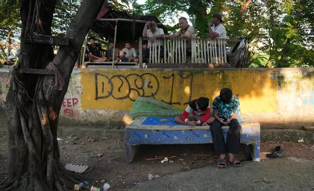 Teenage boys use their mobile phone in Jakarta, Indonesia, March 16, 2026. (AP Photo/Dita Alangkara)