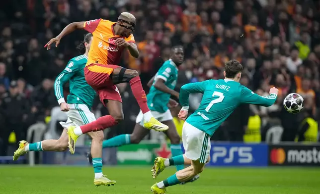 Galatasaray's Victor Osimhen, left, shoots the ball next to Liverpool's Florian Wirtz during a Champions League round of 16 first leg soccer match between Galatasaray and Liverpool, in Istanbul, Turkey, Tuesday, March 10, 2026. (AP Photo/Emrah Gurel)