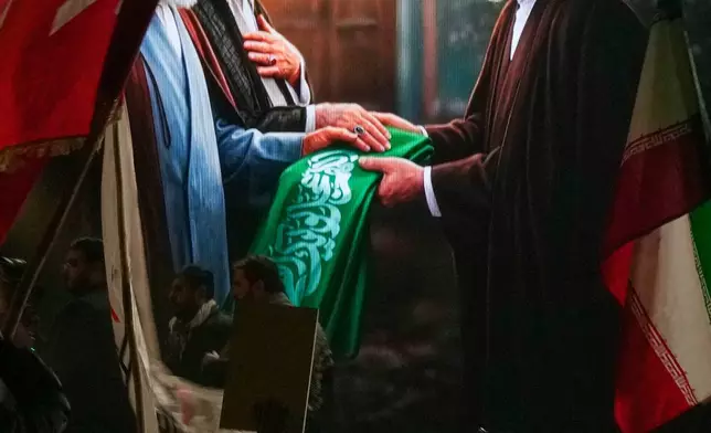 FILE - Protesters wave Iranian flags and hold a portrait of the late Supreme Leader Ayatollah Ali Khamenei and his son Ayatollah Mojtaba Khamenei to support his selection as Iran's new Supreme Leader, in Baghdad, March 9, 2026. (AP Photo/Hadi Mizban, File)