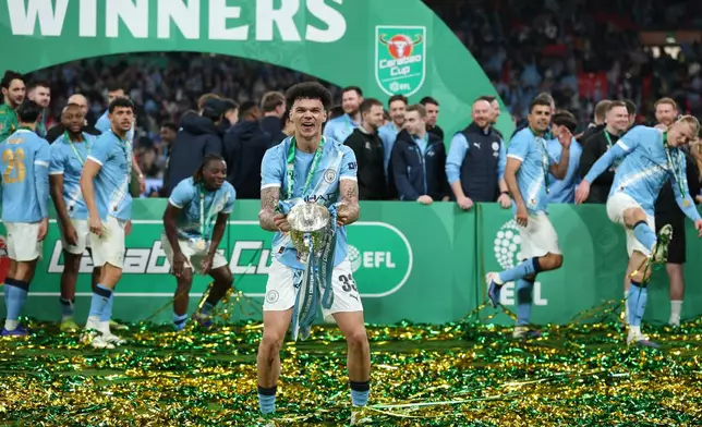 Manchester City's Nico O'Reilly celebrates with the trophy after winning the English League Cup final soccer match between Arsenal and Manchester City in London, Sunday, March 22, 2026. (AP Photo/Richard Pelham)