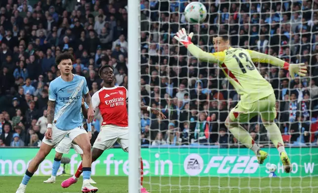 Manchester City's Nico O'Reilly, left, scores his side's second goal during the English League Cup final soccer match between Arsenal and Manchester City in London, Sunday, March 22, 2026. (AP Photo/Richard Pelham)