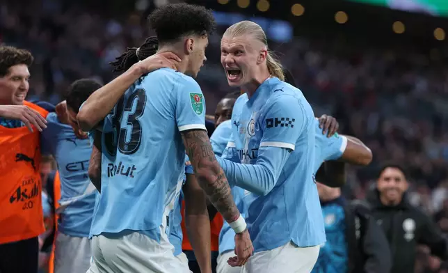 Manchester City's Nico O'Reilly celebrates with Erling Haaland, right, after scoring the opening goal during the English League Cup final soccer match between Arsenal and Manchester City in London, Sunday, March 22, 2026. (AP Photo/Richard Pelham)