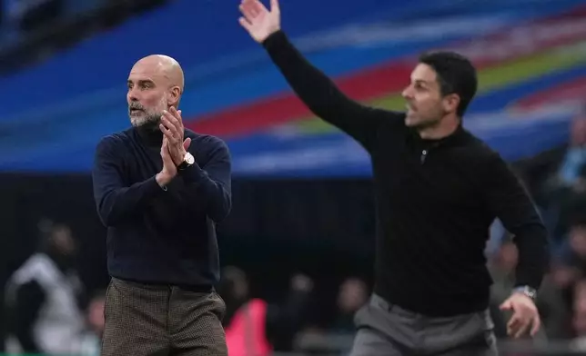 Manchester City's head coach Pep Guardiola, left encourages his players as Arsenal's manager Mikel Arteta gestures to his during the English League Cup final soccer match between Arsenal and Manchester City in London, Sunday, March 22, 2026. (AP Photo/Maja Smiejkowska)