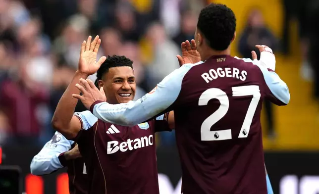 Aston Villa's Ollie Watkins (left) celebrates scoring their side's second goal of the game with teammate Morgan Rogers, during the English Premier League soccer match between Aston Villa and West Ham United, in Birmingham, England, Sunday, March 22, 2026. (Nick Potts/PA via AP)