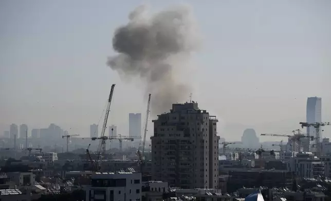 Smoke billows following an Iranian missile strike in Tel Aviv, Tuesday, March 24, 2026. (AP Photo/Ohad Zwigenberg)