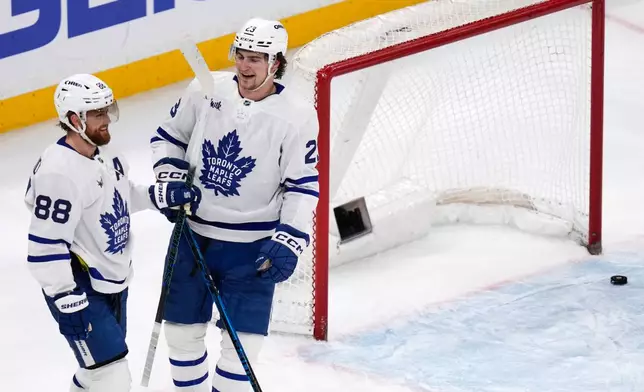 Toronto Maple Leafs left wing Matthew Knies is congratulated by William Nylander (88) after his empty-net goal late in the third period of an NHL hockey game against the Boston Bruins, Tuesday, March 24, 2026, in Boston. (AP Photo/Charles Krupa)