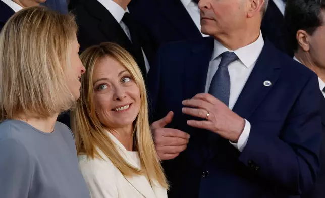 Italy's Prime Minister Giorgia Meloni, center, speaks with European Union foreign policy chief Kaja Kallas, left, during a group photo at an EU summit in Brussels, Thursday, March 19, 2026. (AP Photo/Geert Vanden Wijngaert)